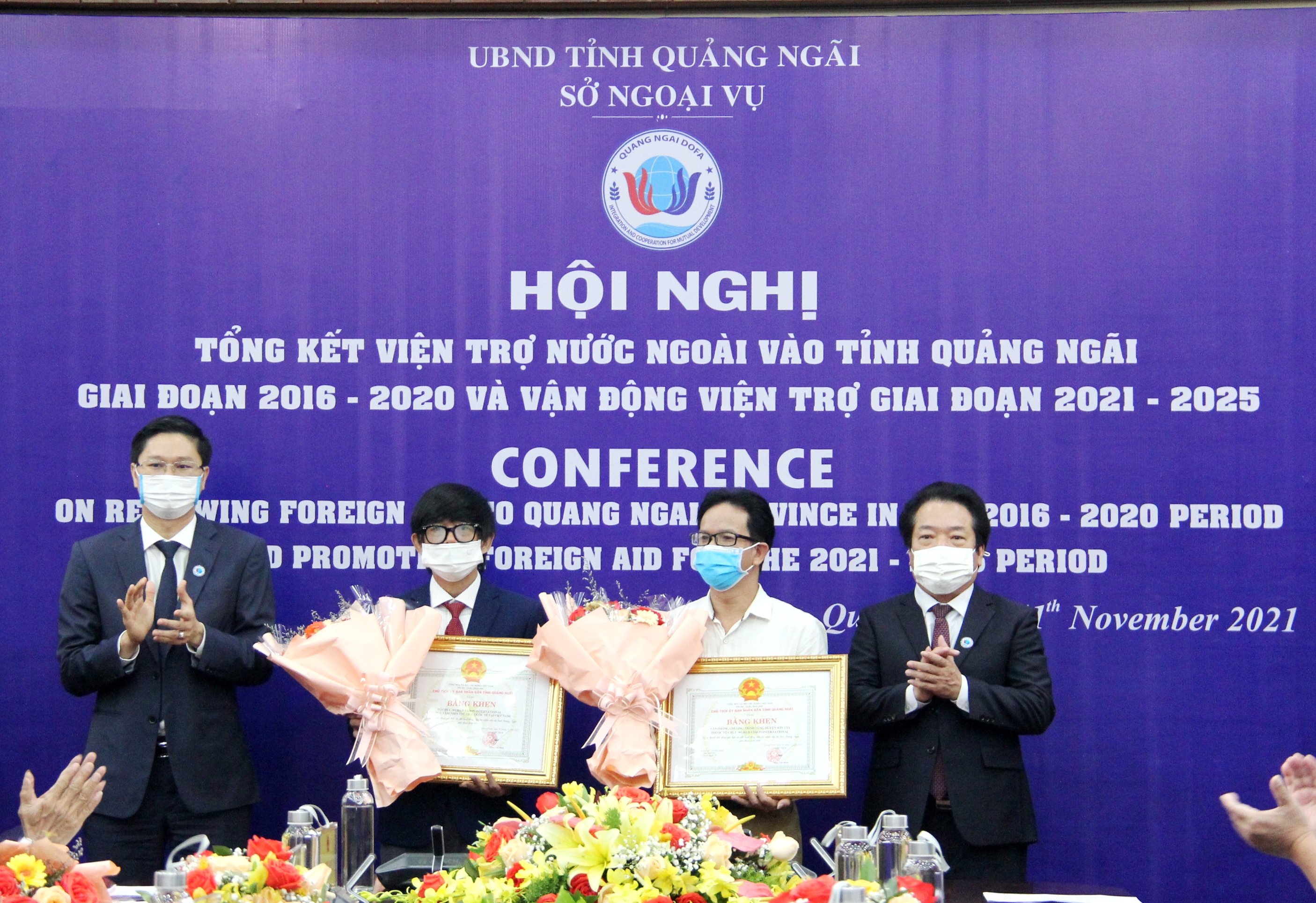 Phó Chủ tịch UBND tỉnh Võ Phiên và Giám đốc Sở Ngoại vụ Nguyễn Viết Vy trao Bằng khen và hoa cho đại diện Tổ chức Tầm nhìn Thế giới tại Việt Nam (WVI)
